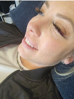 Client smiling after a fresh lash set — post-service glow.