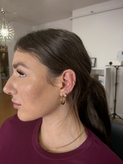 Curated gold ear stack — lobe and cartilage piercings with implant-grade jewelry.