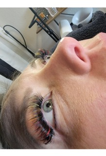 Colorful lash extension close-up with a soft cat-eye lift.
